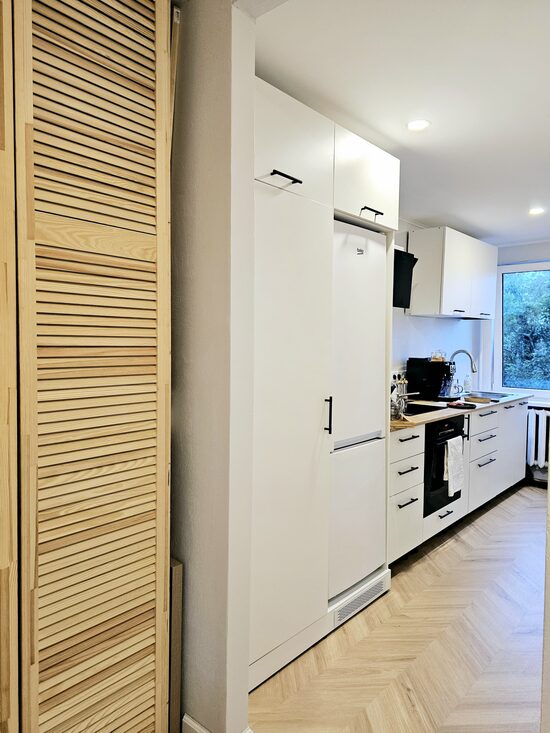 Balta virtuves iekārta ar diviem skapjiem sadzīves elektro tehnikai